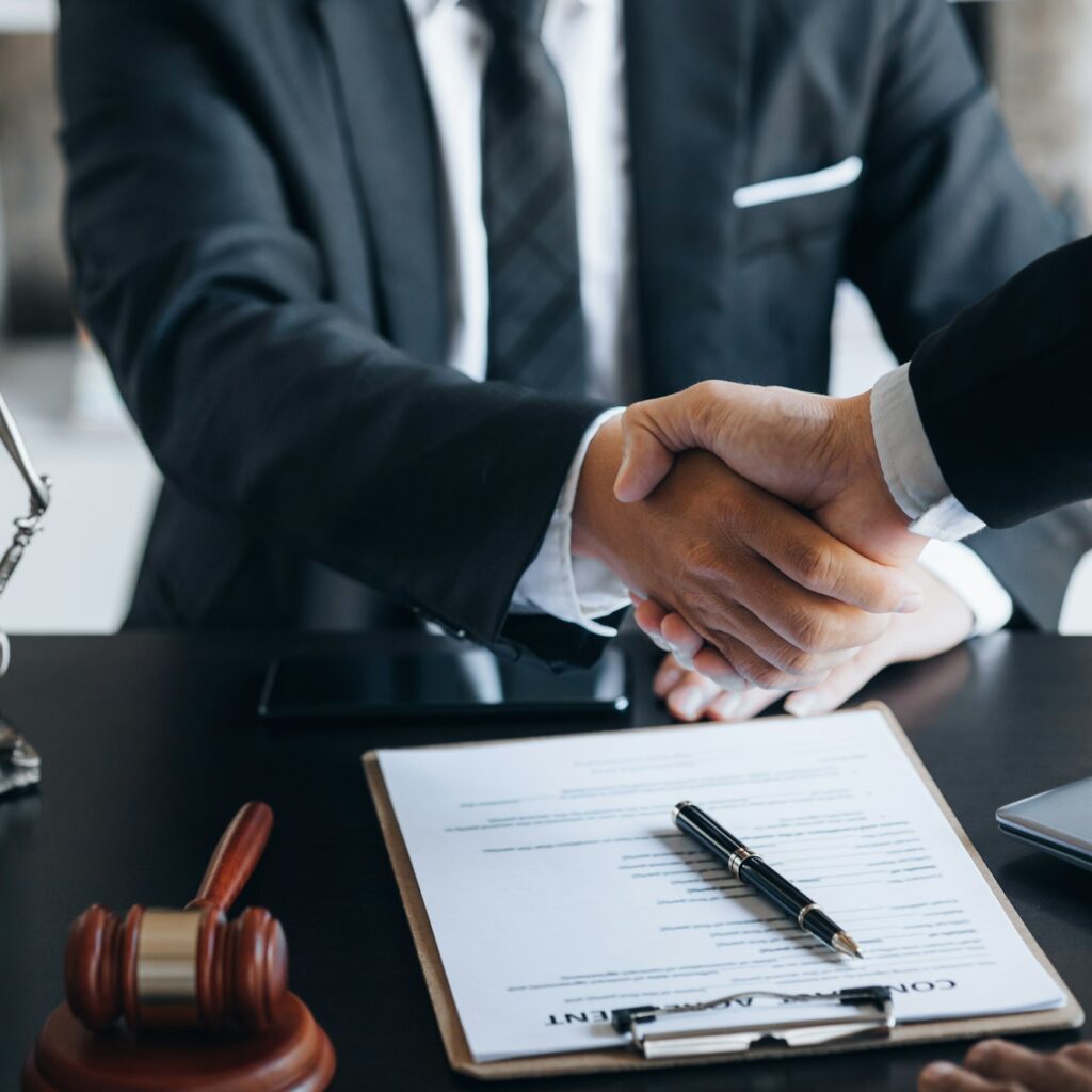 Lawyer and client shake hands, after winning a lawsuit where a lawyer hired.